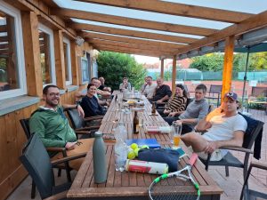 Gruppe von Doppelcup-Teilnehmer sitzt auf der Terrasse des Clubhauses.