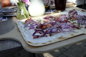 Frisch gebackener Flammkuchen mit Zwiebeln und Speck